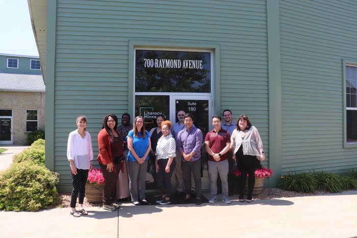 A group of National Service staff and service members stand in front of the Literacy Minnesota office.