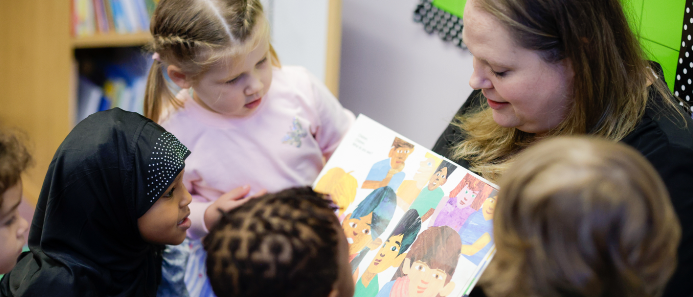 A group of children reading a book together.