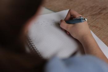 close up of a hand writing on a paper