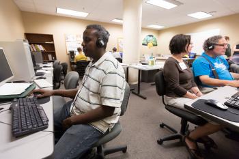 Adult learners working on computers in a computer lab