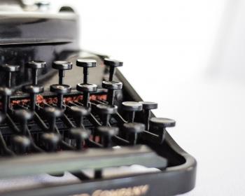 black typewriter with printer paper