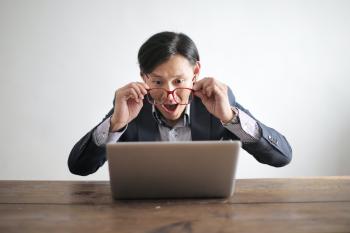 person looking at laptop with delight and amazement 