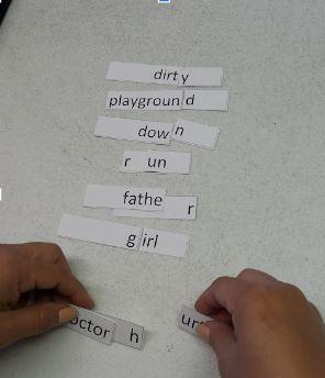 a learner matches small paper cards with the beginnings and ends of words on them