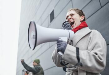 a white woman yells into a bullhorn 