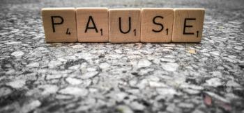 Scrabble tiles spelling the word pause